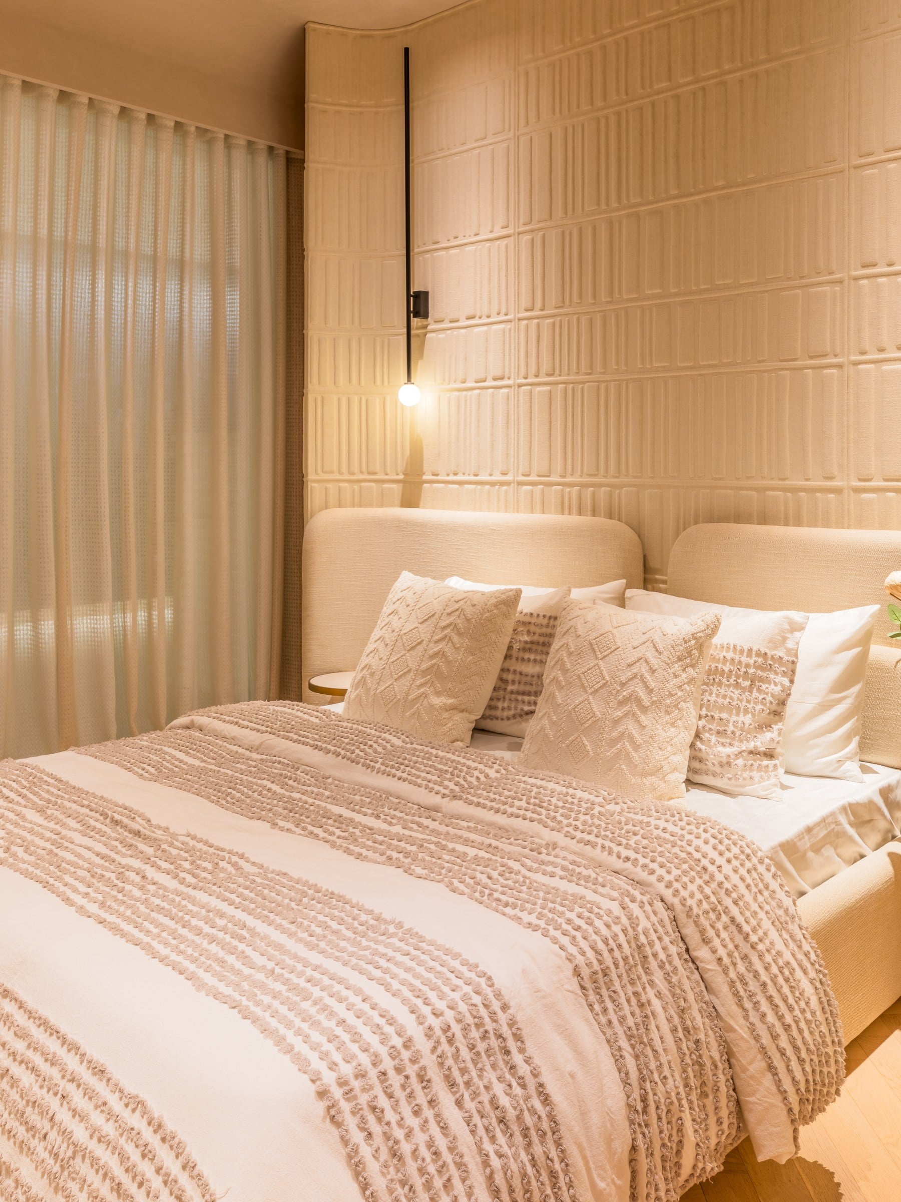 Show residence bedroom with textured headboard wall at The Imperial i